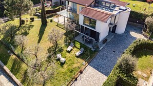 A modern two-story house with a flat roof, large windows, and a spacious patio area. - Villa Violetta (Menaggio)