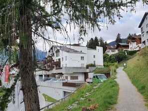 Ein Wohngebiet mit modernen Gebäuden, einem Weg und einem Baum.