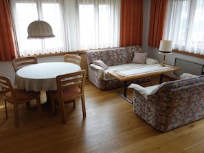Ein gemütliches Wohnzimmer mit einem runden Tisch, zwei Sofas und einer Lampe.