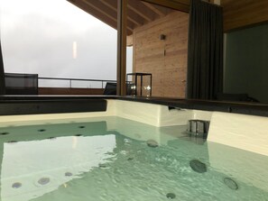 A hot tub with clear water, wooden walls, and a view of the sky. - CATRINA RESORT, (Disentis / Mustér), 2010 by Interhome (Disentis)