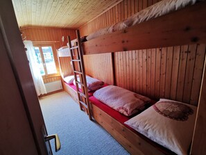 A bunk bed room with wooden walls and a window. - ANSAUNA appartaments, (Segnas/Disentis), 1030 by Interhome (Disentis)