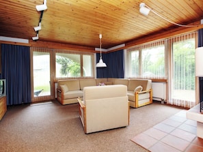 A living room with a sofa, a coffee table, a TV, and large windows with curtains. - Casa Sax 5 Church, (Disentis/Mustér), 1628 by Interhome (Disentis)