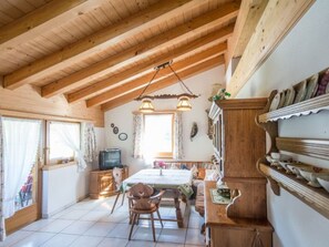 A wooden interior with a dining area, a television, and a shelf with dishes. - Cuntera Venzin, (Curaglia), 5002 by Interhome (Baselgia)