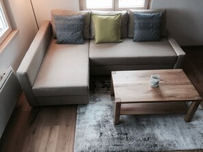 Ein Wohnzimmer mit einer Couch, einem Couchtisch und einem Teppich.