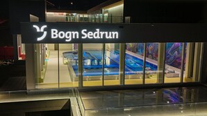 Ein modernes Gebäude mit einem Schild, auf dem 'Bogn Sedrun' steht.