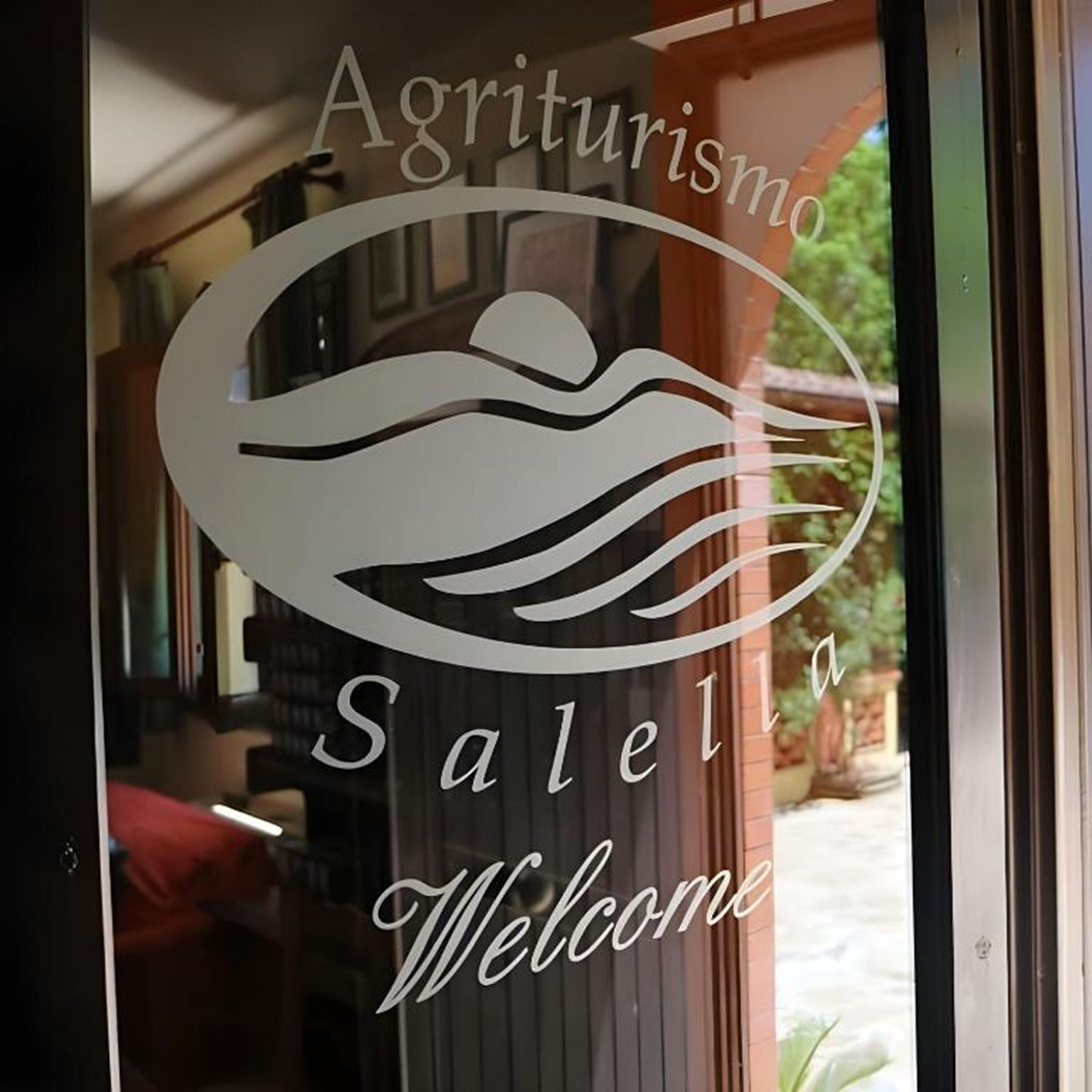 Eine Glastür mit einem Logo und der Aufschrift 'Agriturismo Salella Welcome'.