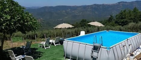 Ein Pool im Freien mit Liegestühlen und Blick auf Berge.