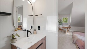 Une salle de bain moderne avec un grand miroir, un meuble-lavabo et un ventilateur de plafond.