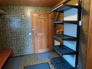 A room with a wooden door, a bench, and a shelving unit with storage compartments. - Tgèsa Margeritha Frei M., (Sedrun), 253.01 by Interhome (Sedrun)