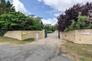 A stone wall entrance to a property with a sign indicating it is for sale. - Gîte La Bergerie – With Pool! (Saint-Michel-en-l'Herm)