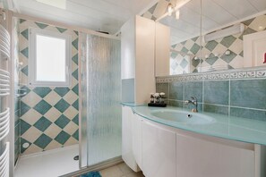 A bathroom with a glass sink, a shower with a diamond-patterned wall, and a white cabinet. - Gîte La Bergerie – With Pool! (Saint-Michel-en-l'Herm)