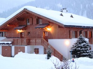 A wooden chalet with a balcony, a staircase leading to the entrance, and a snow-covered roof. - Casa Mulinera 1 GVH, (Camischolas/Sedrun), 243.01 by Interhome (Camischolas)
