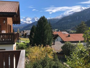 A residential area with houses, a wooden balcony, and a mountain backdrop. - Casa Mulinera 1 GVH, (Camischolas/Sedrun), 243.01 by Interhome (Camischolas)