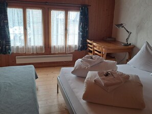 A room with a bed, a desk, a chair, and a window with curtains. - Biala Casa Pintga Streiff, (Rueras), by Interhome (Rueras Dieni)
