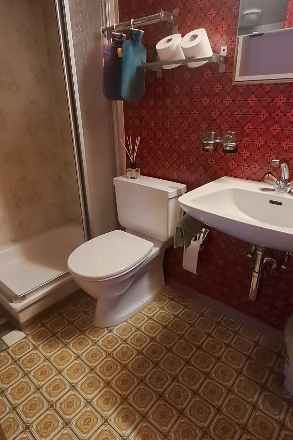 A bathroom with a toilet, sink, and shower.