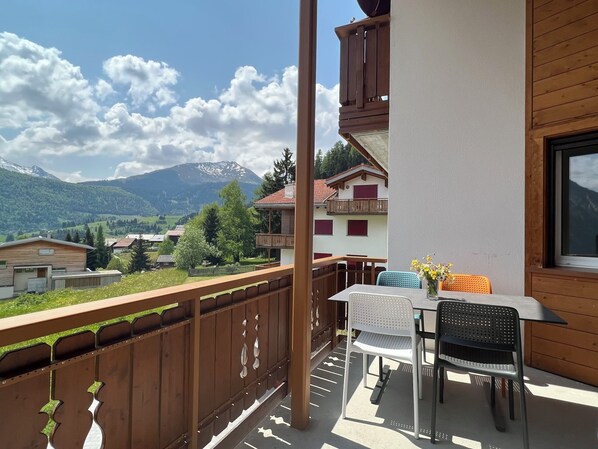 A balcony with a table and chairs, a view of mountains, and a wooden fence. - Casa Diala Panorama, (Segnas/Disentis), 1106 by Interhome (Disentis)