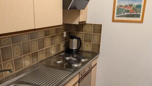 Eine Küche mit Spüle aus Edelstahl, einer Kaffeemaschine und einem Herd.