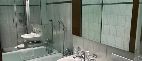 A modern bathroom with a glass-enclosed shower, a freestanding bathtub, and a vanity with a sink and mirror.