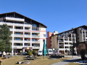 Ein mehrstöckiges Hotel mit Balkonen, Außenbereich und einem Parkplatz.