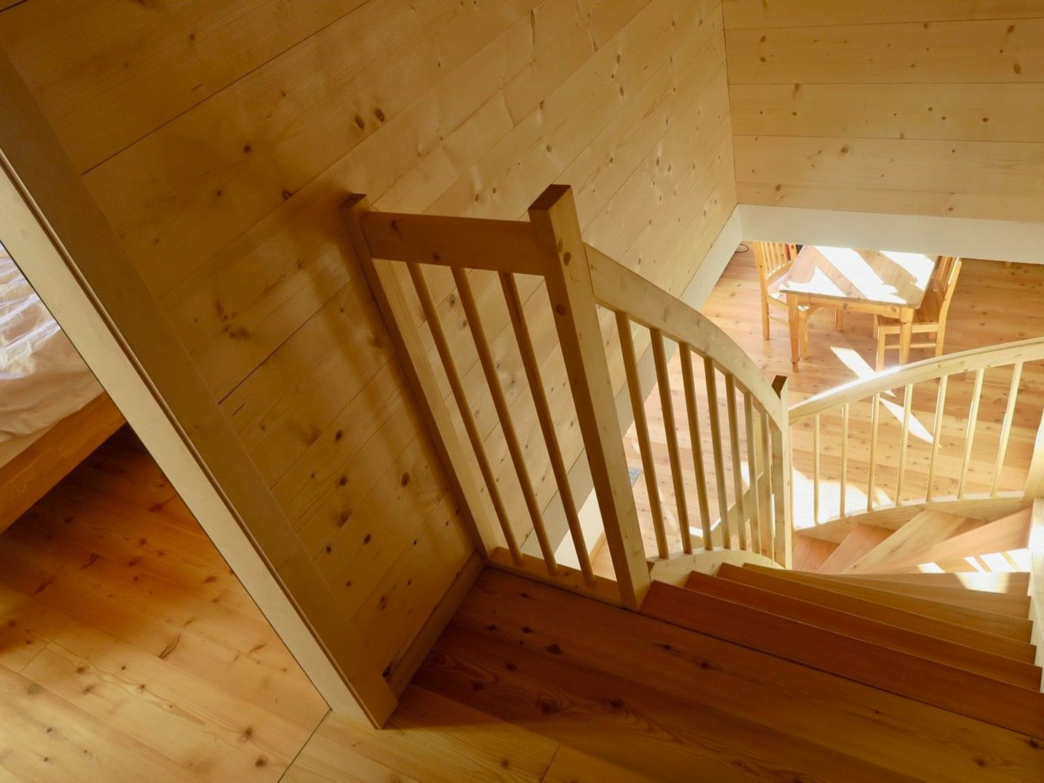 Un escalier en bois, doté d’une rampe, mène à un niveau supérieur.
