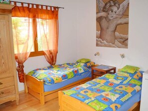 A room with two wooden beds, a wooden wardrobe, a small table, and a wall-mounted shelf. - Tgèsa Bostgé Grubenmann, (Sedrun), 154.01 by Interhome (Sedrun)