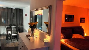 Een slaapkamer met een bed, een kaptafel, een spiegel en een bureau met een stoel.