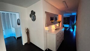 Een moderne badkamer met een douche, spiegel en handdoekhouder.