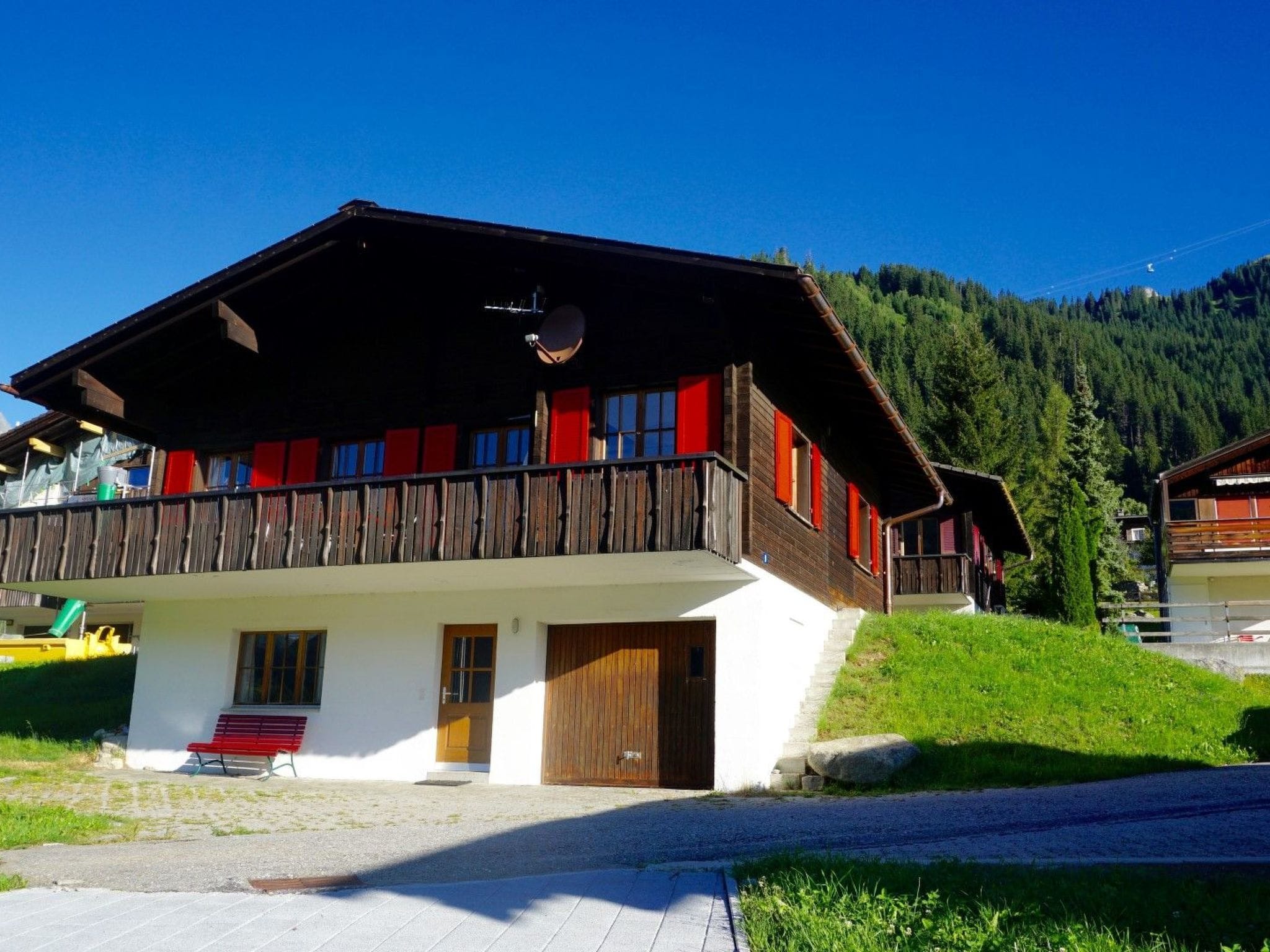 Un chalet doté d’un toit en pente, d’un balcon en bois et d’une porte en bois.
