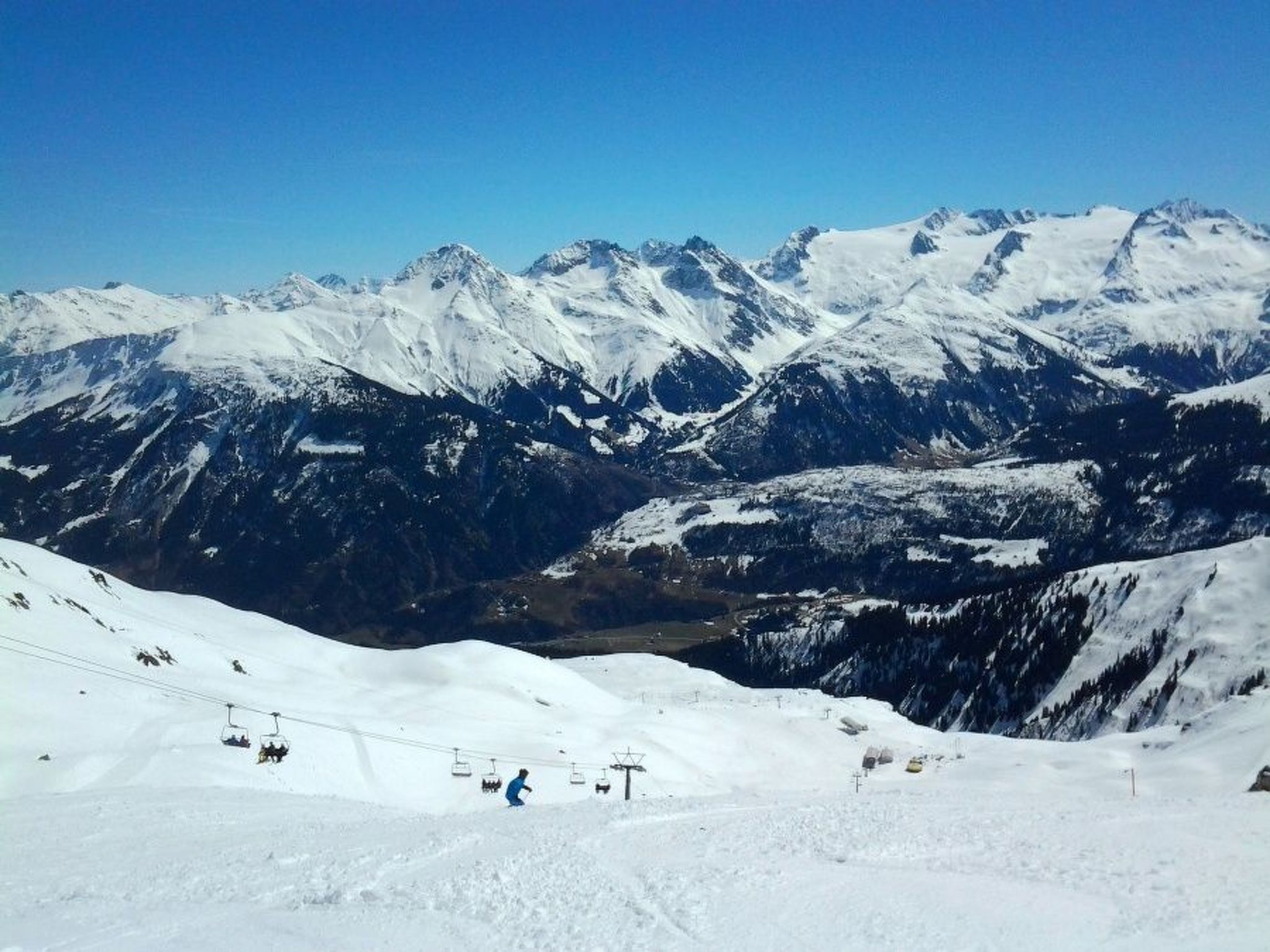 Een besneeuwd berglandschap met skiliften en een heldere lucht.