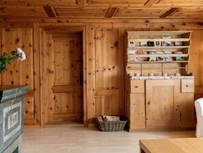 Ein Holzkaminzimmer mit Kamin, Holzregalen mit Büchern und einem Holzscheitkorb.