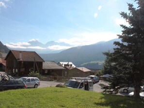 A mountainous landscape with a row of buildings and parked cars. - Tgèsa Pitgmun Aufdenblatten, (Sedrun), 168.01 by Interhome (Sedrun)
