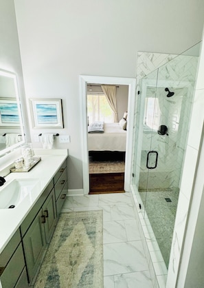 Une salle de bain avec une douche, un lavabo et un miroir.
