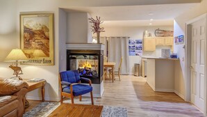 A living room with a fireplace, a sofa, a blue armchair, a wooden coffee table, and a rug. - Blk to Shuttle|BBQ|Near Gondola, Breck Rec Cntr (Breckenridge)