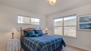 A bedroom with a bed, two bedside tables, a ceiling fan, and large windows. - Blk to Shuttle|BBQ|Near Gondola, Breck Rec Cntr (Breckenridge)