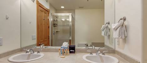 A bathroom with two sinks, a large mirror, and a wooden vanity.