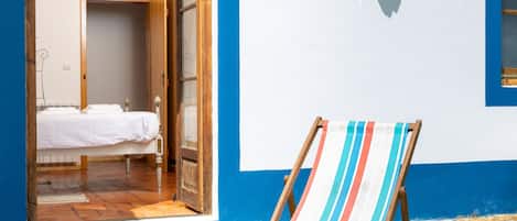 Una habitación con cama, una puerta abierta que da a otra estancia y vistas a la playa.