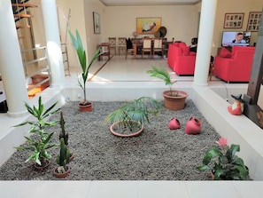 A spacious living area with a central seating arrangement, a television, and a variety of potted plants. - VILLA FATI by Interhome (Tróia)