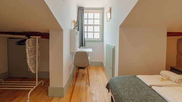A narrow room with a bed, a desk, and a window. - Apartment  by Interhome (Porto)