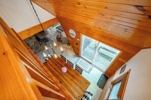 A high-ceilinged wooden interior with a dining area, kitchen, and large windows. - New! Beautiful Lake Views and Lake Fun! (McHenry)