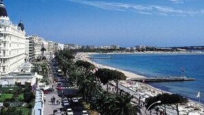 A coastal cityscape with a prominent white building with a dome, a beach, and a pier extending into the sea. - Studio with balcony Palais Royal 103 by Interhome (Cannes)