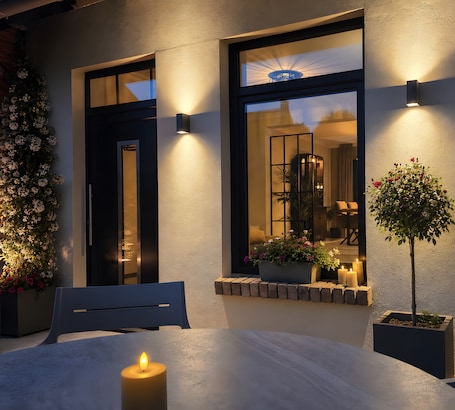 A well-lit outdoor seating area with a table, chairs, and a candle.. Apartment 'Marina' with Private Terrace and Wi-Fi