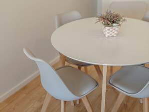 A round table with a checkered tablecloth, surrounded by four grey chairs with wooden legs. - Apartment  by Interhome (Porto)