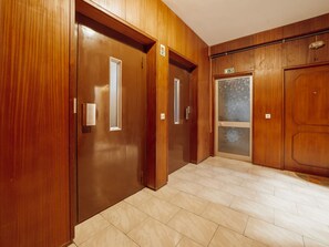 A hallway with wooden doors and a tiled floor. - GOOD MORNING APARTMENT with GARAGE by VACATIONY by Interhome (Porto)