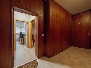 A room with wooden flooring, a door labeled '22', and a visible kitchen area with stools and a counter. - GOOD MORNING APARTMENT with GARAGE by VACATIONY by Interhome (Porto)