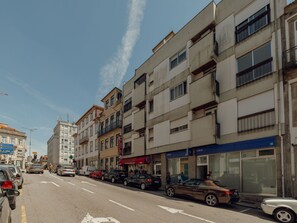 Un edificio de varios pisos con locales comerciales en la planta baja, incluyendo una farmacia y un banco.