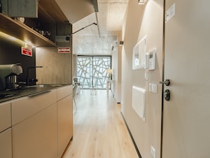 A modern kitchen with a coffee machine, a dining area with a table and chairs, and a large window with a view. - Apartment  by Interhome (Porto)