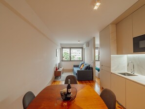 Um apartamento moderno com sala de jantar, cozinha e sala de estar.