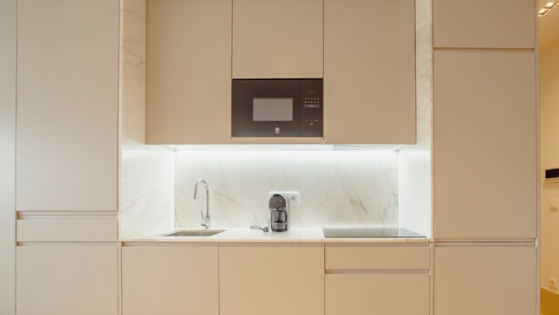 A modern kitchen with a built-in coffee maker, a sink, and a microwave. - Apartment  by Interhome (Porto)