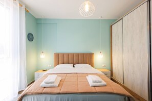 Ein Hotelzimmer mit einem Bett, zwei Nachttischen, einem Wanduhren und einem großen Kleiderschrank.