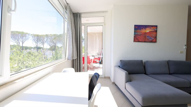 En stue med en sofa, et bord og et billede på væggen.